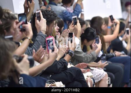 Die Gäste fotografieren auf ihrem Handy bei der Kit Neale Modenschau während der London Collections: Men des British Fashion Council im Old Sorting Office in London. Stockfoto