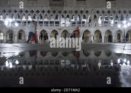 Der Dogenpalast spiegelte sich in einer Pfütze in Venedig, Italien wider Stockfoto