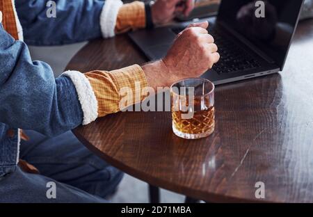 Nahaufnahme von Senioren in modischer Kleidung, die funktioniert Mit Laptop Stockfoto