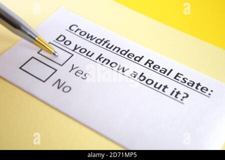 Eine Person beantwortet Frage über Crowdfunding Immobilien. Stockfoto