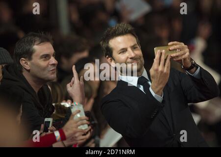 Bradley Cooper posiert für Selfies mit Fans, während er zur gebrannten Premiere im Vue West End, Leicester Square, London, ankommt. Stockfoto