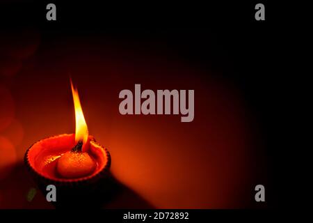 Happy Diwali - eine Diya Öltonlampe beleuchtet während Diwali Feier mit Kopierraum. Hinduistische Kultur Ritual festliche Feier während Corona pa Stockfoto
