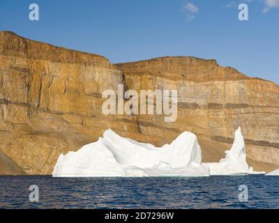 Landschaft mit steilen gelben Klippen und Eisbergen im Fjordsystem Uummannaq im Norden westgrönlands. Amerika, Nordamerika, Grönland, Den Stockfoto