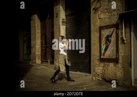 Barcelona, Spanien. Oktober 2020. Ein Fotojournalist fotografiert ein Graffiti des italienischen Stadtkünstlers 'TVBoy', Salvatore Benintende, mit dem Titel 'Was dich nicht tötet, macht dich stärker. Oder nicht?“ Darstellung von US-Präsident Donald Trump in einem Superman-Kostüm, das inmitten von Coronavirus-Wolken fliegt Quelle: Matthias Oesterle/Alamy Live News Stockfoto