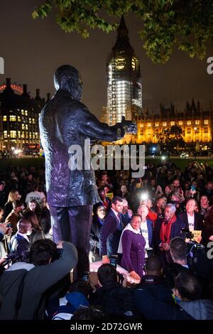 Menschen wie Graa Machel (Mitte, violetter Mantel), abgebildet unter der Statue von Nelson Mandela auf dem Parliament Square in London, nach einem symbolischen "Walk Together"-marsch mit den Ältesten, einer von Nelson Mandela gegründeten Gruppe globaler Führer, die vor Mandelas Statue auf dem parliament Square endete. Bilddatum: Montag, 23. Oktober 2017. Bildnachweis sollte lauten: Matt Crossick/ EMPICS Entertainment. Stockfoto