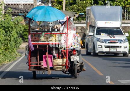 SAMUT PRAKAN, THAILAND, JUNI 13 2020, EINE Verkäuferfahrt auf einem motorisierten Dreirad auf einer Straße. Der mobile Stall mit frischem Obst und Essen. Stockfoto