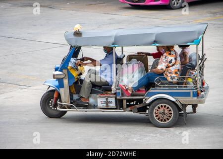 SAMUT PRAKAN, THAILAND, JULI 25 2020, die Familie mit vollen Taschen fährt in einem traditionellen Motor-Dreirad-Tuk-Tuk Stockfoto