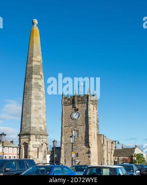 Der Steinobelisk (Marktkreuz) und die Holy Trinity Church im Market Place in Richmond, North Yorkshire Stockfoto