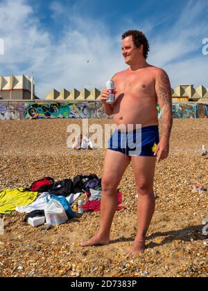 BRIGHTON, GROSSBRITANNIEN - 2. JUNI: Der Litauische Karolis Petraska, der in London lebt und arbeitet, genießt an einem heißen Tag am Brighton Beach ein kaltes Bier. Stockfoto