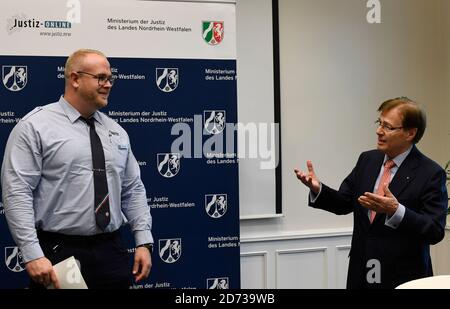 20. Oktober 2020, Nordrhein-Westfalen, Düsseldorf: Peter Biesenbach (CDU, r) Justizminister des Landes Nordrhein-Westfalen, dankt Daniel Freihoff (l) mit einer Urkunde und einem Einkaufsgutschein für seine Bemühungen. Anfang September rettete ein Angestellter des Gefängnisses Kleve ein kleines Kind aus der rechten Fahrspur der Autobahn 3, das von seinen Eltern unbemerkt den nahegelegenen Rastplatz verlassen hatte und auf die Straße rannte. Foto: Roberto Pfeil/dpa Stockfoto