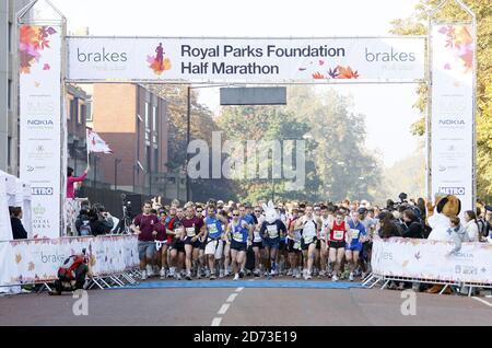 Beim Halbmarathon der Royal Parks Foundation in Hyde Park, London, überqueren die Teilnehmer die Startlinie. Über 10,000 Läufer liefen 13.1 Meilen durch vier Royal Parks und endeten beim Brakes Food and Fitness Festival im Hyde Park. Stockfoto