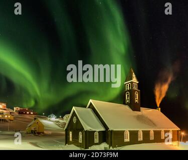 Nordlichter über der Zions Kirche. Stadt Ilulissat am Ufer der Disko Bay in Westgrönland, Zentrum für Tourismus, Verwaltung und Wirtschaft. Th Stockfoto