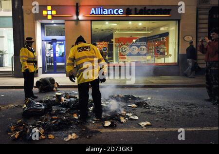 Eine brennende Barrikade schwelt in der City of London, nach einem Tag von Protesten, die auf dem "Financial Fools Day" rund um die Bank of England basieren. Stockfoto