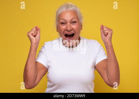 Kaukasische reife Frau schreien ja halten Fäuste oben Stockfoto