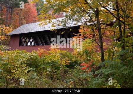 Wunderschöne Vermont überdachte Brücke von bunten Herbstlaub umgeben. Stockfoto