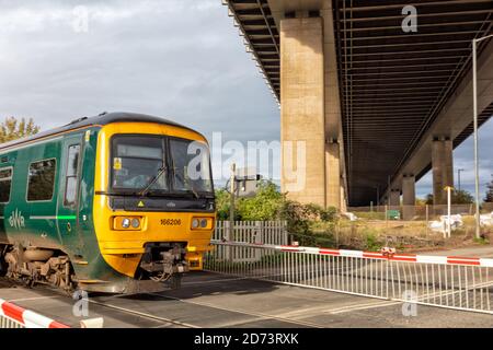 Great Western Railway Zug fährt unter der Avonmouth Brücke, die die Autobahn M5 über den Fluss Avon, Bristol, England, Großbritannien Stockfoto