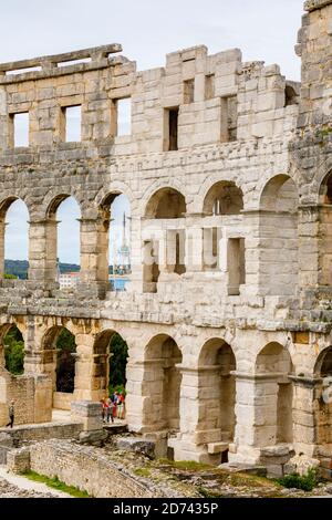 Details von Bögen und Säulen in den Außenwänden des ikonischen antiken römischen Amphitheaters in Pula, Istrien, Kroatien, eine führende Touristenattraktion Stockfoto