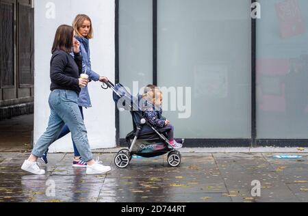 Dundee, Tayside, Schottland, Großbritannien. Oktober 2020. UK Wetter: Ein heller Tag mit einigen sonnigen Zauber in Nord-Ost-Schottland, maximale Temperaturen 12 Grad. Eine Einzelperson, die mit zwei Kindern einen Kinderwagen schiebt, während sie im Stadtzentrum von Dundee einkaufen, während die Covid-19 Sperrbeschränkungen gelten. Kredit: Dundee Photographics/Alamy Live Nachrichten Stockfoto