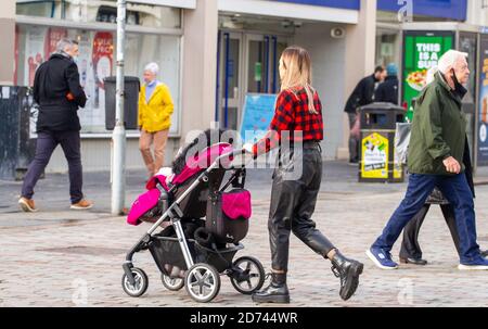 Dundee, Tayside, Schottland, Großbritannien. Oktober 2020. UK Wetter: Ein heller Tag mit einigen sonnigen Zauber in Nord-Ost-Schottland, maximale Temperaturen 12 Grad. Eine Einzelperson, die mit ihrem Kind einen Kinderwagen schiebt, während sie im Stadtzentrum von Dundee einkaufen, während die Covid-19-Sperrbeschränkungen gelten. Kredit: Dundee Photographics/Alamy Live Nachrichten Stockfoto