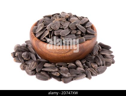 Sonnenblumenkerne isoliert auf weißem Hintergrund. Haufen gebratener Sonnenblumenkerne in Holzschüssel. Stockfoto