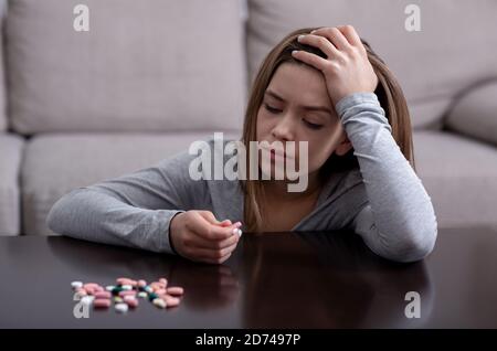 Hoffnungslose junge Frau mit Depression planen, Selbstmord zu begehen Überdosierung auf Medikamente zu Hause Stockfoto