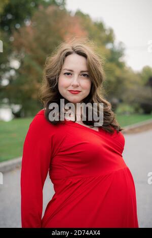 Frau in einem roten Kleid für Mutterschaftsfotos Stockfoto