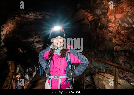 Frau Reisende erkunden Lava-Tunnel in Island. Raufarholshellir ist eine schöne versteckte Welt der Höhle. Es ist eine der längsten und bekanntesten Lava