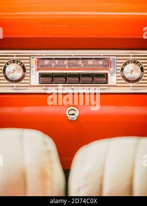 Altes Autoradio in einem orangefarbenen klassischen amerikanischen Auto mit chrom-Dashboard Stockfoto