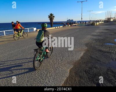 Menschen, die Fahrrad fahren in einer Promenade. Passeig Marítim del Bogatell, Barcelona, Katalonien, Spanien. Stockfoto