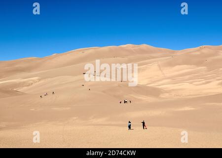 Menschen Wandern in den höchsten Sanddünen Nordamerikas. Great Sand Dunes National Park. Sangre de Cristo Mountains in Colorado, USA Stockfoto