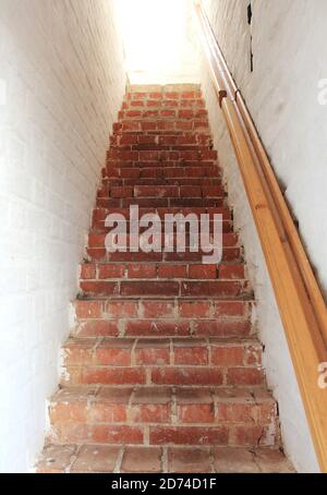 Steinerne schmale Treppe in einem alten Backsteingebäude Stockfoto