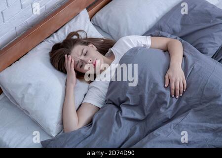 Psychologische Gesundheitsfürsorge. Traurige Dame, die allein im Bett liegt, an Depressionen leidet oder Schlafstörungen hat, Draufsicht Stockfoto