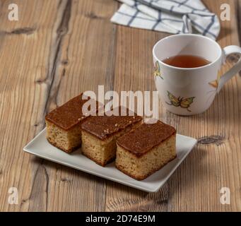 Brauner Kuchen und eine Tasse Tee über einem Holz Tabelle Stockfoto