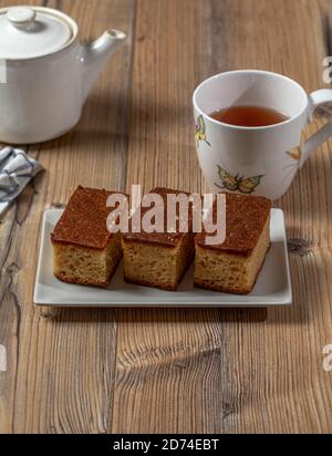 Brauner Kuchen und eine Tasse Tee über einem Holz Tabelle Stockfoto