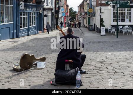 Rückansicht des Straßenmusikers, der klassische Gitarre spielt, auf dem Gipfel des Steep Hill, Lincoln, UK Stockfoto