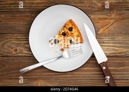 Stück Kuchen mit Quark Souffle und Pflaume mit Mandeln und Heidelbeeren auf Holztisch dekoriert. Draufsicht. Stockfoto
