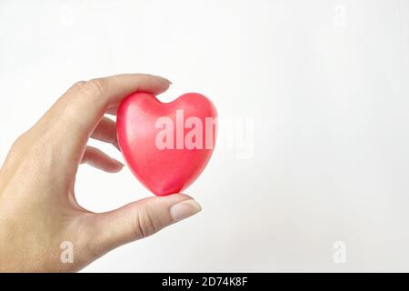 Frau Hand halten rote Herz auf dem weißen Hintergrund. Krankenversicherung, Spende, Lebensretterkonzept. Welt Herz Gesundheit Tag Idee Stockfoto