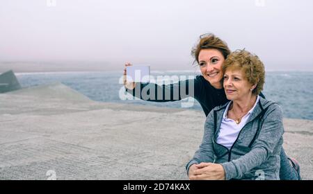 Trainer nimmt Selfie mit älteren Frau Stockfoto