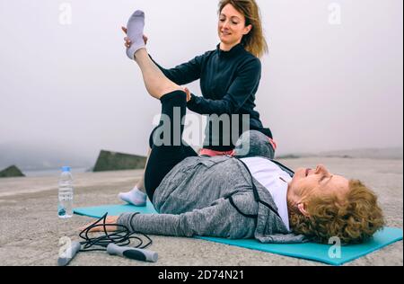 Ältere Frau mit Personal Trainer Stockfoto