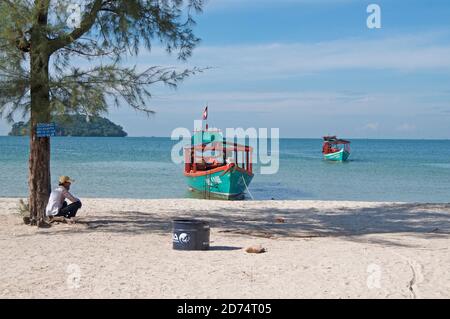 Otres Beach, Sihanoukville, Kambodscha - 30. Dezember 2018 : schöne Küste von Otres Beach mit einem Bootsmann sitzt auf dem weißen Sand und zwei typische Stockfoto