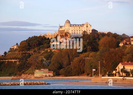 Das Hotel Real liegt am frühen Morgen auf einem Hügel Orangefarbenes Sonnenlicht von der Playa de los Bikinis Magdalena aus gesehen Halbinsel Santander Kantabrien Spanien Stockfoto