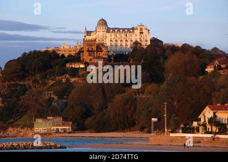 Das Hotel Real liegt am frühen Morgen auf einem Hügel Orangefarbenes Sonnenlicht von der Playa de los Bikinis Magdalena aus gesehen Halbinsel Santander Kantabrien Spanien Stockfoto