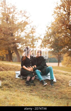Foto von einem jungen netten Paar Mann berühren Frau Bauch im Park. Stockfoto