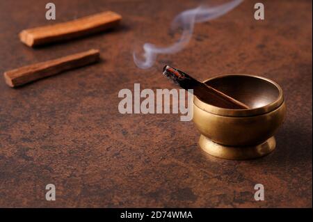 Aromatischer Stab von palo santo auf dunklem Hintergrund. Heiliges heiliges Baumstäbchen, brennend mit Duftrauch.Räuchern von Kräuterräuchern. Heilung, Meditation, Entspannung Stockfoto