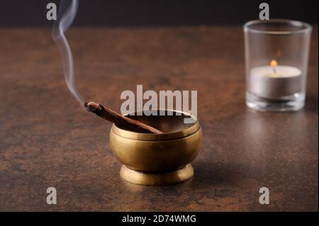 Aromatischer Stab von palo santo auf dunklem Hintergrund. Heiliges heiliges Baumstäbchen, brennend mit Duftrauch.Räuchern von Kräuterräuchern. Heilung, Meditation, Entspannung Stockfoto