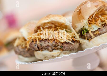 Nahaufnahme eines kleinen amerikanischen Hamburgersnacks mit Schinken und Käsechips. Party-Vorspeise. Stockfoto