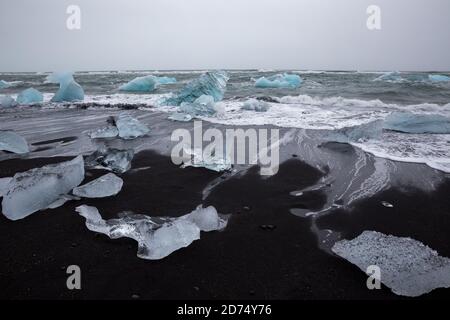 Schwarzer Sand mit Eisbergbrocken am Diamond Beach, Island Stockfoto