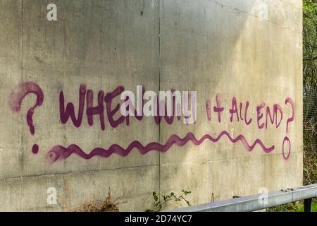 Graffiti fragt, wann alles enden wird? Gemalt unter einer Brücke in Bezug auf die Coronavirus covid-19 Pandemie im Jahr 2020, Großbritannien Stockfoto