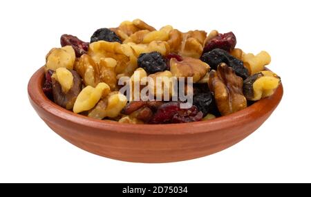 Seitenansicht einer Portion Nüsse und getrocknete Früchte Trail Mix in einer kleinen Tonschale isoliert auf einem weißen Hintergrund. Stockfoto