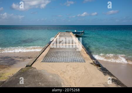 Frederiksted, St. Croix, amerikanische Jungferninseln-Januar 4,2020: Motorboot, das am Ende des Betonmegels mit dem Karibischen Meer auf der Insel St. Croix festgemacht ist Stockfoto